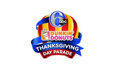 a logo for the 6abc dunkin' donuts thanksgiving day parade featuring a striped red and yellow background with a blue ribbon and a coffee cup icon.
