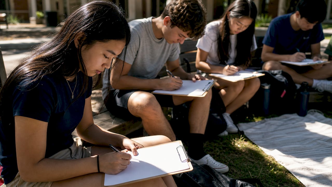 students filling out medical forms outdoors