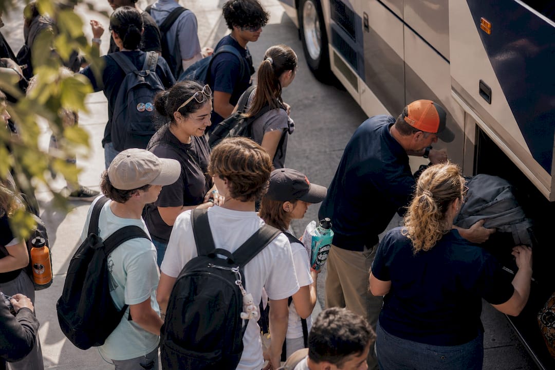 school trip insurance cost: what administrators pay in 2026 4 students boarding bus for group travel