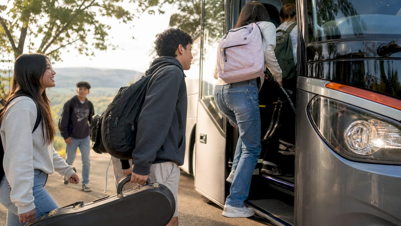 school group bus cost: what districts actually pay in 2026 3 students boarding modern coach bus outside