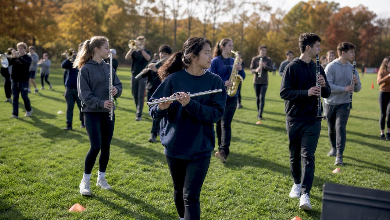 students rehearsing marching band outdoors