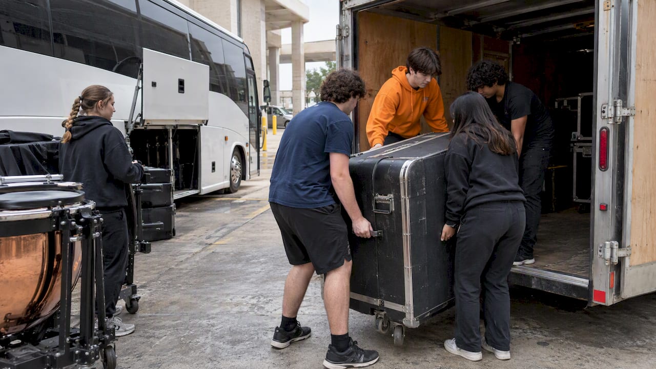 Students loading percussion gear into a trailer