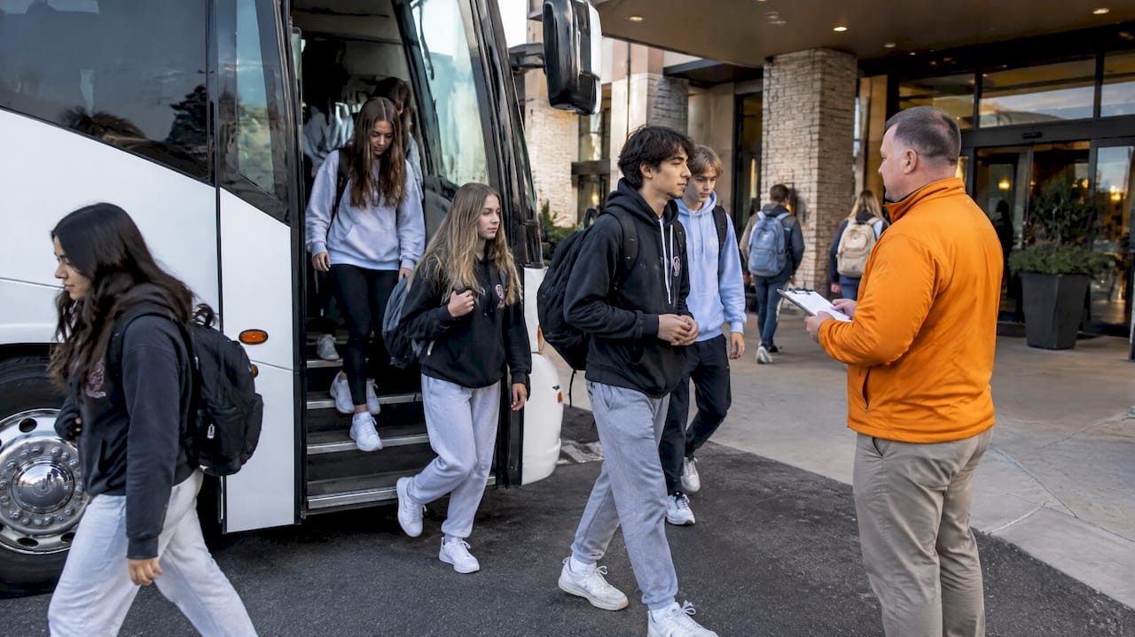 24/7 Hotel Security for Students: Room Checks, Chaperones Per Floor 2 Chaperone counting students beside a coach